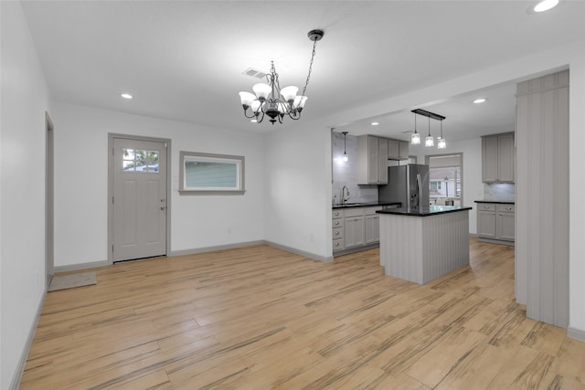 2934 Robertson St, Houston, TX 77009 - kitchen featuring stainless steel fridge with ice dispenser, dark countertops, light wood-style flooring, a chandelier, and recessed lighting