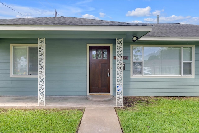 2934 Robertson St, Houston, TX 77009 - view of exterior entry featuring a yard, a shingled roof, and covered porch