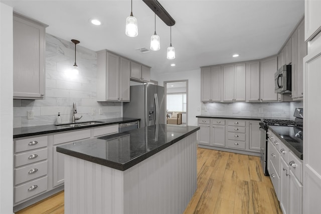 2934 Robertson St, Houston, TX 77009 - kitchen with stainless steel appliances, decorative backsplash, light wood finished floors, decorative light fixtures, and recessed lighting