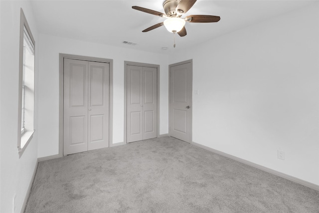 2934 Robertson St, Houston, TX 77009 - unfurnished bedroom with carpet floors, two closets, and a ceiling fan