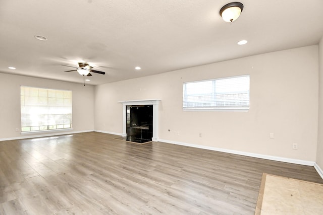 3502 Quail Meadow Dr, Missouri City, TX 77459 - unfurnished living room featuring a ceiling fan, recessed lighting, wood finished floors, and a fireplace with flush hearth