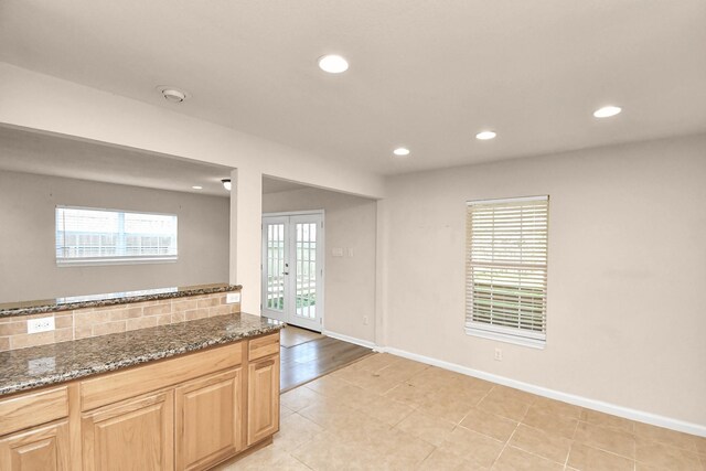 3502 Quail Meadow Dr, Missouri City, TX 77459 - kitchen featuring french doors, recessed lighting, dark stone countertops, light brown cabinetry, and light tile patterned floors