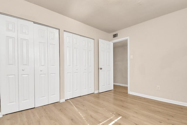 3502 Quail Meadow Dr, Missouri City, TX 77459 - unfurnished bedroom featuring two closets and light wood finished floors