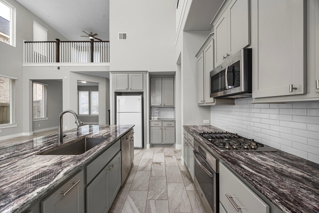 13207 Terania Cliff Trce, Houston, TX 77059 - kitchen featuring stainless steel appliances, gray cabinetry, ceiling fan, and a high ceiling