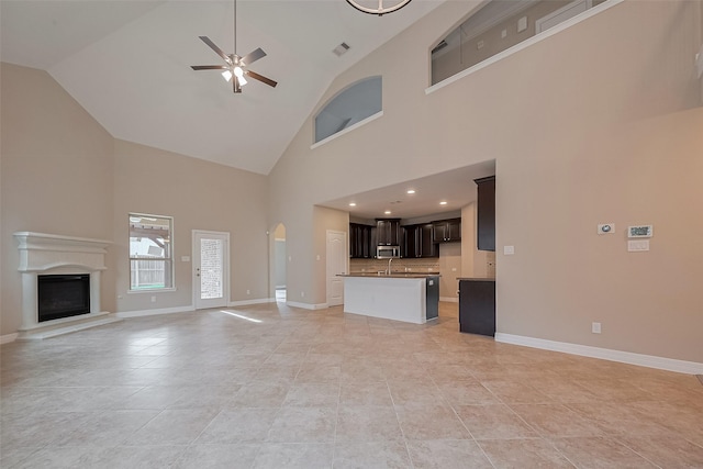 11607 Carisio Ct, Richmond, TX 77406 - unfurnished living room with a ceiling fan, high vaulted ceiling, a fireplace with raised hearth, and arched walkways