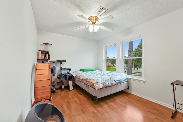 4790 Whispering Falls Dr, Houston, TX 77084 - bedroom featuring light wood-style flooring, a ceiling fan, and a textured ceiling