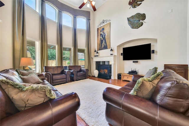 5714 Spring River Ln, Fulshear, TX 77441 - living area with wood finished floors, ceiling fan, a fireplace with flush hearth, and a high ceiling