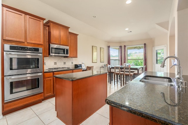 22911 Banff Brook Way, Tomball, TX 77375 - kitchen with stainless steel appliances, a center island, tasteful backsplash, brown cabinets, and recessed lighting