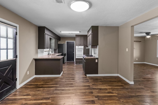 109 Timber Ln, Baytown, TX 77520 - kitchen featuring appliances with stainless steel finishes, dark wood-style floors, light stone counters, a warming drawer, and a ceiling fan