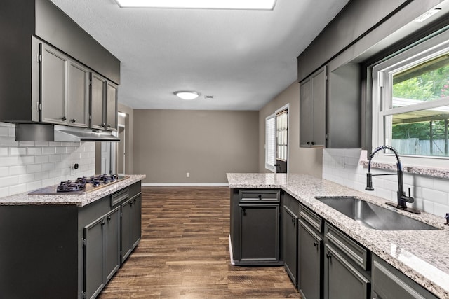 109 Timber Ln, Baytown, TX 77520 - kitchen featuring stainless steel gas cooktop, decorative backsplash, dark wood-type flooring, and a peninsula