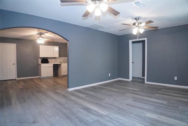 6803 6th St, Hitchcock, TX 77563 - unfurnished living room featuring ceiling fan, arched walkways, and dark wood-type flooring