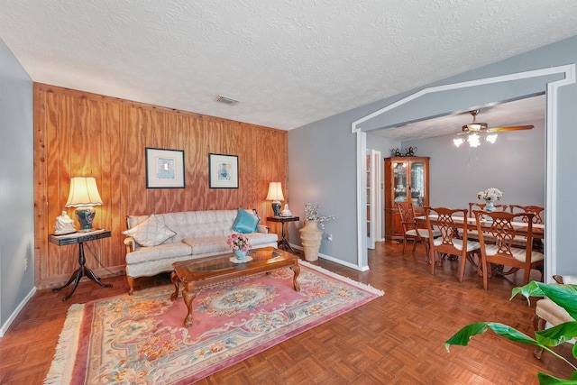11815 Sharpview Dr, Houston, TX 77072 - living room featuring wood walls, a ceiling fan, and a textured ceiling