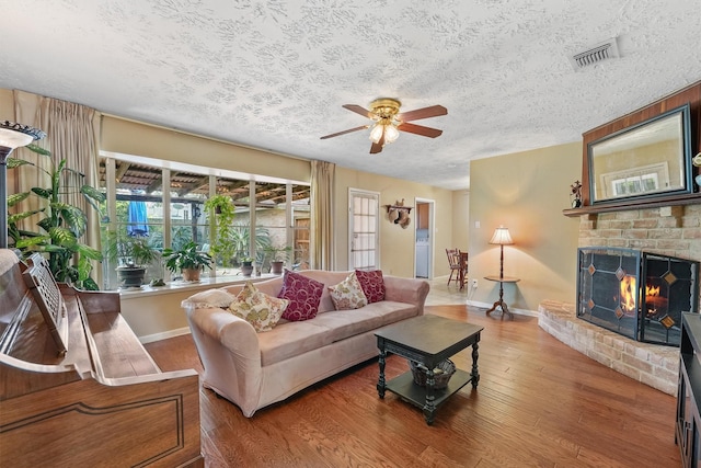 11815 Sharpview Dr, Houston, TX 77072 - living area featuring a textured ceiling, ceiling fan, wood finished floors, and a fireplace