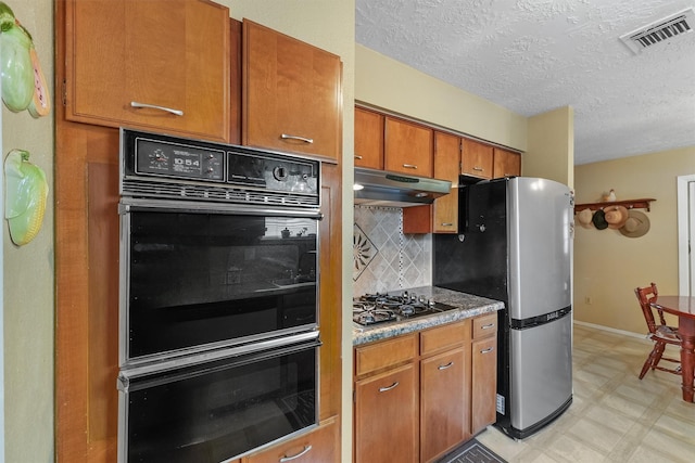 11815 Sharpview Dr, Houston, TX 77072 - kitchen with stainless steel appliances, brown cabinetry, decorative backsplash, under cabinet range hood, and light floors