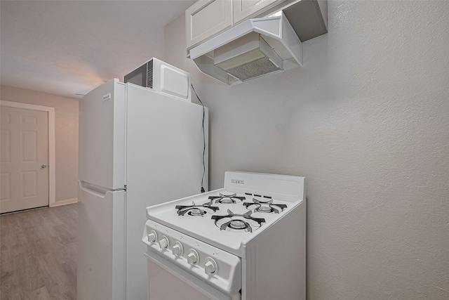 1813 Hatwell St, Houston, TX 77023 - kitchen with white appliances, wood finished floors, white cabinets, and under cabinet range hood