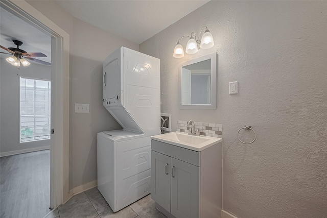 1813 Hatwell St, Houston, TX 77023 - bathroom with stacked washer / dryer, vanity, ceiling fan, backsplash, and tile patterned flooring