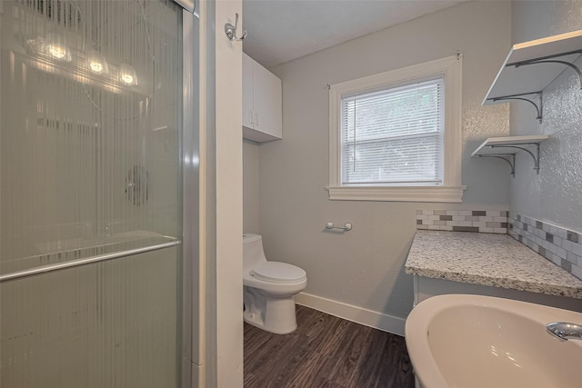 1813 Hatwell St, Houston, TX 77023 - bathroom featuring wood finished floors, a stall shower, and backsplash