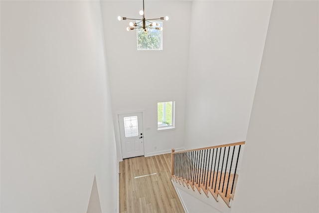 7410 Hezekiah Ln, Houston, TX 77088 - stairway featuring a chandelier, wood finished floors, plenty of natural light, and a high ceiling