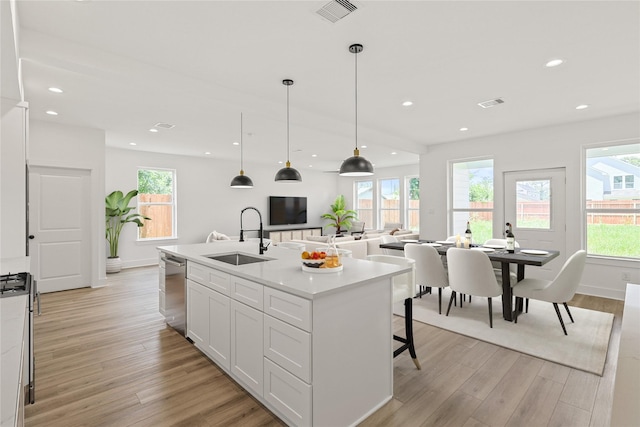 7410 Hezekiah Ln, Houston, TX 77088 - kitchen with dishwasher, light wood-style flooring, white cabinetry, light countertops, and recessed lighting