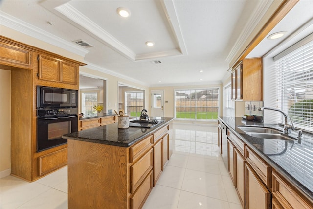 2125 Tipperary Dr, Pearland, TX 77581 - kitchen with black appliances, a kitchen island, brown cabinetry, ornamental molding, and dark stone counters