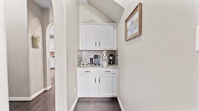 14926 Kenton Place Ln, Cypress, TX 77429 - indoor wet bar with dark wood finished floors, backsplash, arched walkways, lofted ceiling, and a textured wall