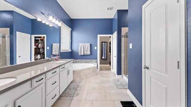 14926 Kenton Place Ln, Cypress, TX 77429 - bathroom featuring a shower stall, a bath, double vanity, tile patterned flooring, and a spacious closet
