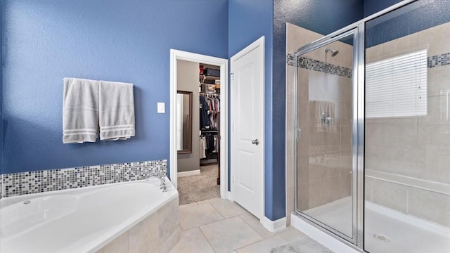 14926 Kenton Place Ln, Cypress, TX 77429 - bathroom with a shower stall, a garden tub, a spacious closet, tile patterned flooring, and a textured wall