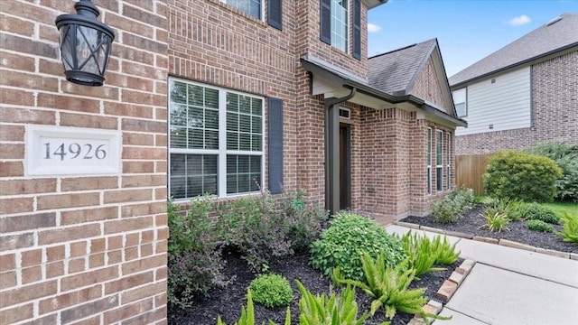 14926 Kenton Place Ln, Cypress, TX 77429 - view of exterior entry featuring brick siding and a shingled roof