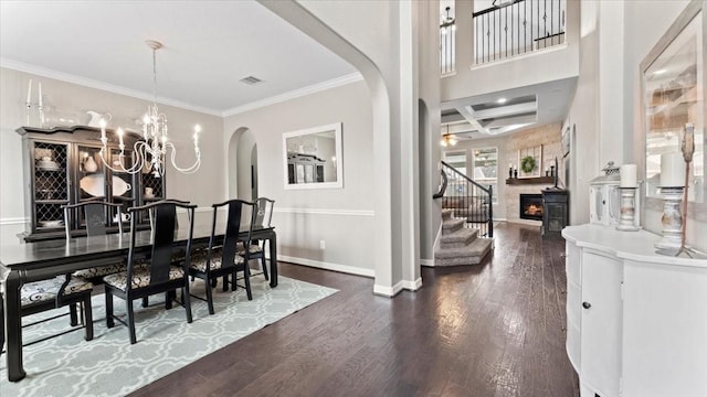 14926 Kenton Place Ln, Cypress, TX 77429 - dining space featuring arched walkways, stairs, dark wood-style flooring, a chandelier, and crown molding