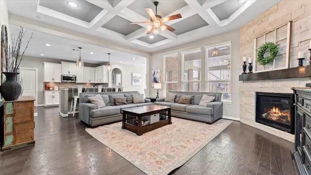 14926 Kenton Place Ln, Cypress, TX 77429 - living area with a ceiling fan, arched walkways, a stone fireplace, dark wood finished floors, and coffered ceiling
