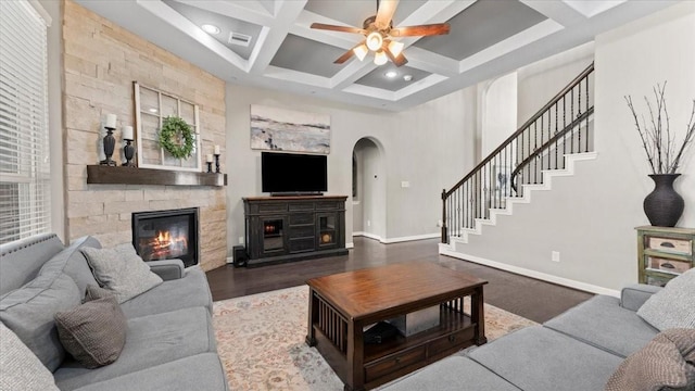 14926 Kenton Place Ln, Cypress, TX 77429 - living area with a stone fireplace, arched walkways, coffered ceiling, a ceiling fan, and beamed ceiling