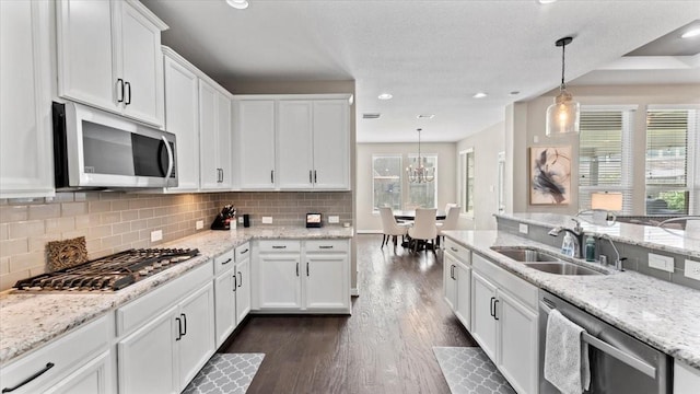 14926 Kenton Place Ln, Cypress, TX 77429 - kitchen featuring stainless steel appliances, dark wood finished floors, white cabinets, pendant lighting, and recessed lighting