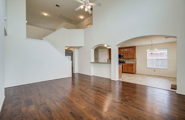 11610 Cross Spring Dr, Pearland, TX 77584 - unfurnished living room with ceiling fan, light wood finished floors, arched walkways, a chandelier, and a high ceiling
