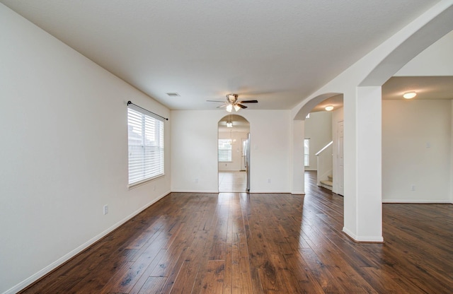 11610 Cross Spring Dr, Pearland, TX 77584 - unfurnished living room with arched walkways, stairway, dark wood-style floors, and ceiling fan