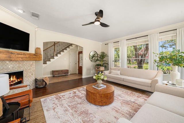 5406 Winlock Trace Ct, Katy, TX 77450 - living room featuring a ceiling fan, crown molding, wood finished floors, stairway, and a fireplace