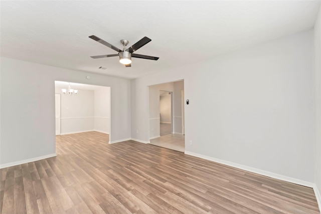 25515 Pepper Ridge Ln, Spring, TX 77373 - empty room with a chandelier, light wood-style floors, and a ceiling fan