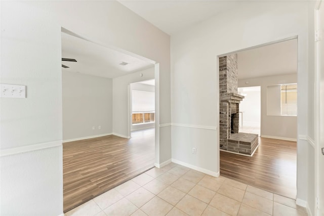 25515 Pepper Ridge Ln, Spring, TX 77373 - spare room featuring wood finished floors, a ceiling fan, a fireplace, and healthy amount of natural light