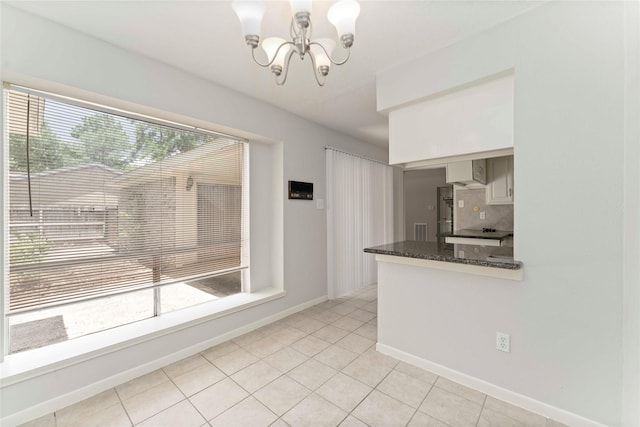 25515 Pepper Ridge Ln, Spring, TX 77373 - kitchen featuring a chandelier, backsplash, light tile patterned floors, dark stone countertops, and decorative light fixtures
