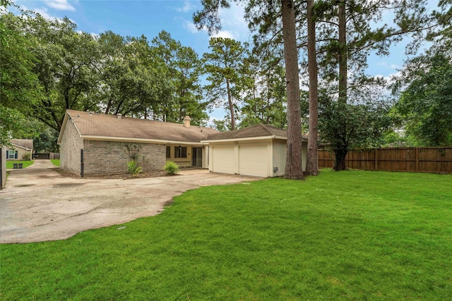 25515 Pepper Ridge Ln, Spring, TX 77373 - back of house featuring a garage, concrete driveway, a chimney, and brick siding