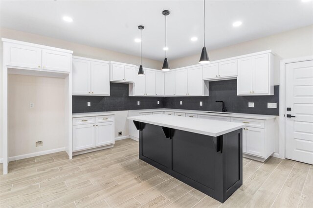 4120 S Kemp Ave, Edinburg, TX 78542 - kitchen featuring light wood-style flooring, white cabinets, a center island, decorative backsplash, and recessed lighting
