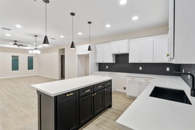 4120 S Kemp Ave, Edinburg, TX 78542 - kitchen with dark cabinets, white cabinets, tasteful backsplash, recessed lighting, and a center island