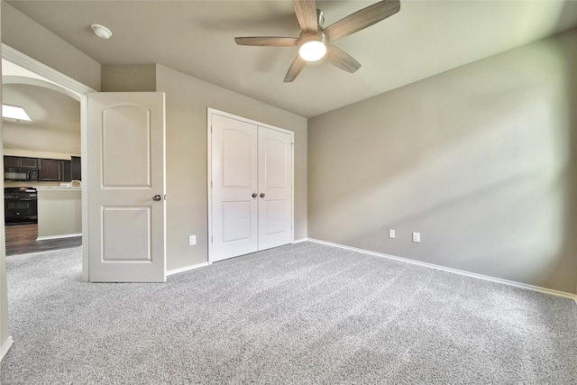1959 Briar Grove Dr, Conroe, TX 77301 - unfurnished bedroom with carpet flooring, a closet, arched walkways, and a ceiling fan