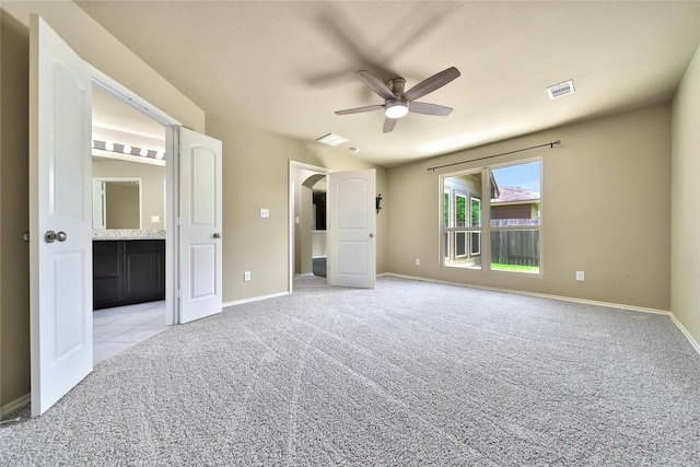 1959 Briar Grove Dr, Conroe, TX 77301 - unfurnished bedroom featuring light carpet, connected bathroom, arched walkways, and a ceiling fan