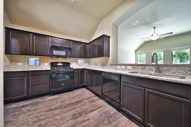 1959 Briar Grove Dr, Conroe, TX 77301 - kitchen with black appliances, vaulted ceiling, a ceiling fan, dark brown cabinets, and wood finished floors