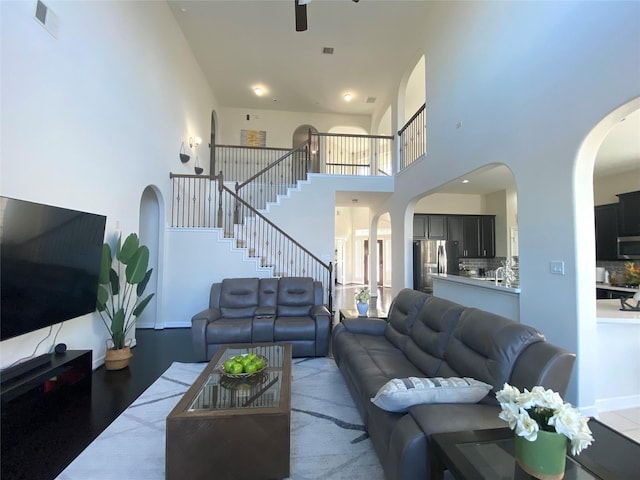 20718 Slate Ct, Richmond, TX 77407 - living area featuring arched walkways, a high ceiling, ceiling fan, and stairway