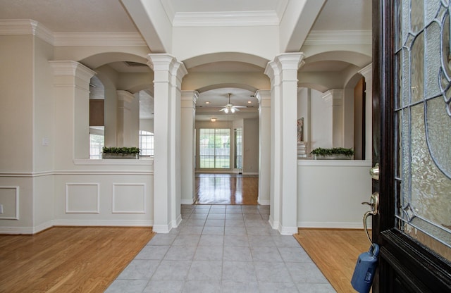 16214 Lobo Ln, Spring, TX 77379 - entryway featuring a ceiling fan, light wood-style floors, crown molding, decorative columns, and arched walkways