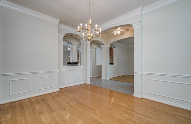 16214 Lobo Ln, Spring, TX 77379 - unfurnished dining area with arched walkways, ceiling fan, ornate columns, a decorative wall, and wood finished floors