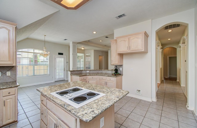 16214 Lobo Ln, Spring, TX 77379 - kitchen with white electric stovetop, light brown cabinets, arched walkways, backsplash, and light tile patterned flooring