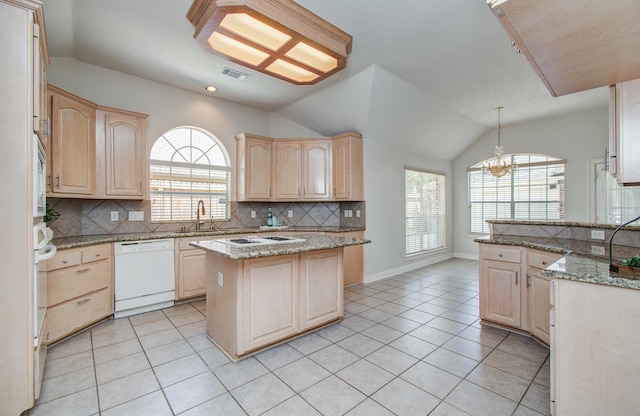 16214 Lobo Ln, Spring, TX 77379 - kitchen with white appliances, light brown cabinetry, decorative backsplash, light tile patterned floors, and lofted ceiling