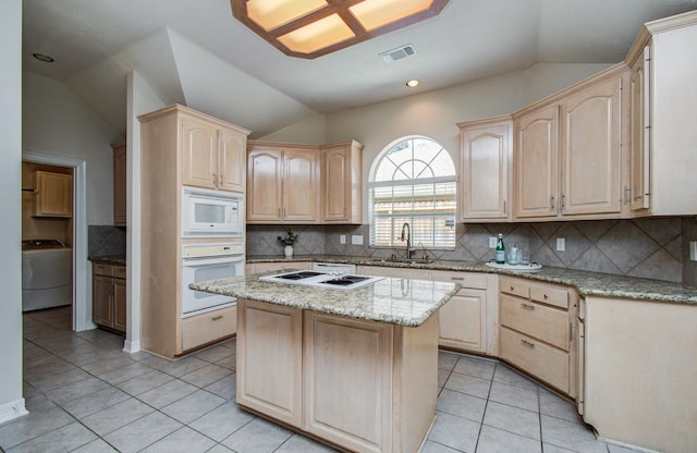 16214 Lobo Ln, Spring, TX 77379 - kitchen with white appliances, washer / clothes dryer, light brown cabinets, lofted ceiling, and light tile patterned floors